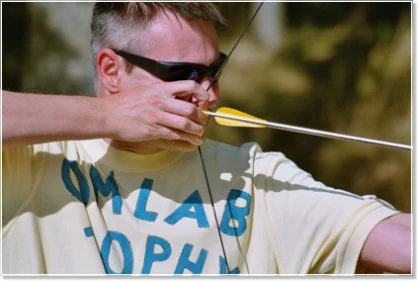 Mitarbeiter beim Bogenschießen während eines Outdoor-Teamevents