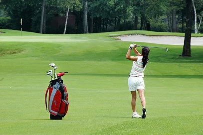 Golferin mit einem Distanzschlag auf Golfkurs in Ligurien