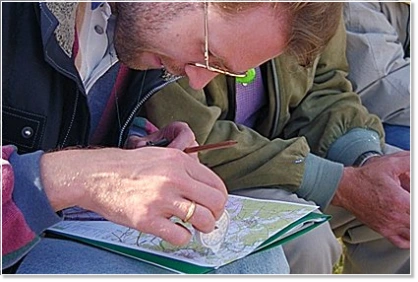 Führungskraft bei der Orientierung im Gelände mit topographischer Karte