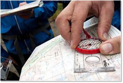 Mitarbeiter bei der Orientierung mit Karte und Kompass während eines Outdoor-Teamevents