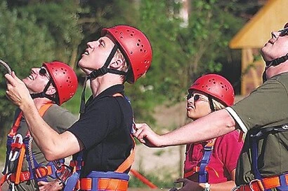 Mitarbeiterteam beim Sichern im Hochseilgarten Teamtraining im Hochseilgarten