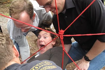 Teambuilding während Firmenevent beim Durchqueren des sogenannten Spinnennetzes